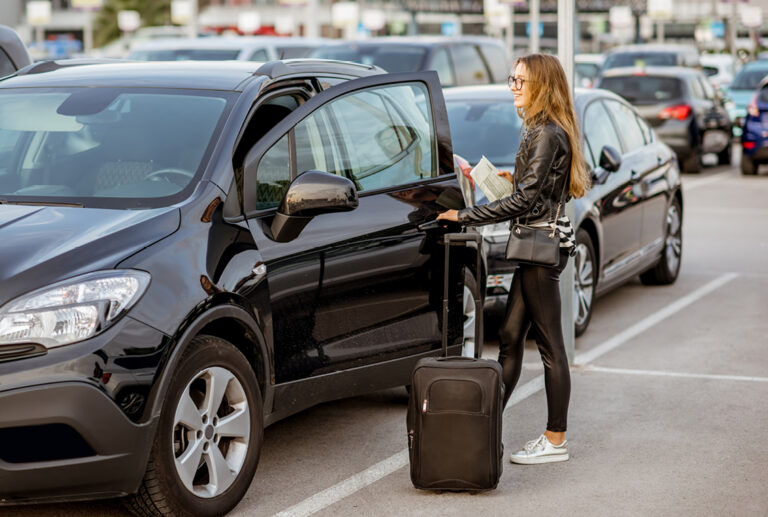 Woman getting into a rental car.