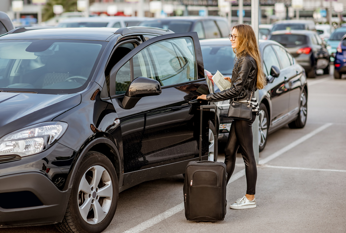 Woman getting into a rental car.