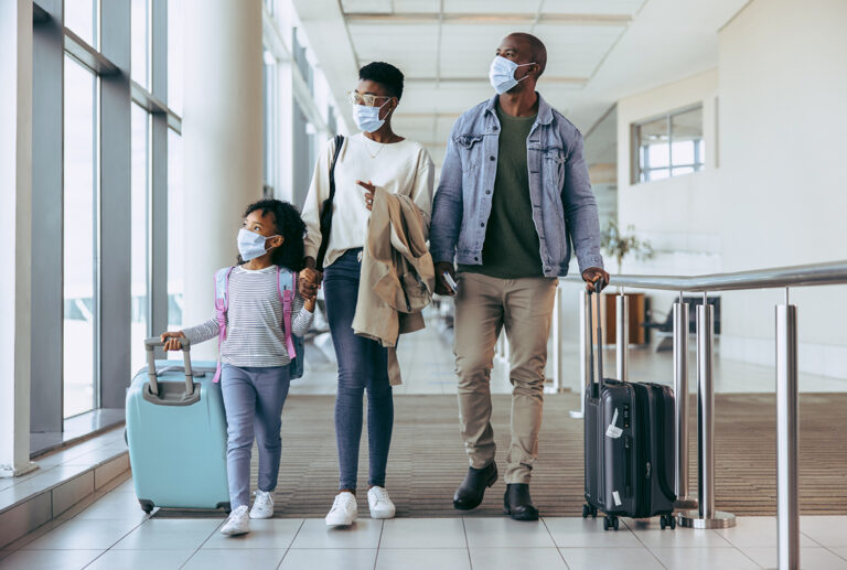 Family in airport with luggage ready to travel
