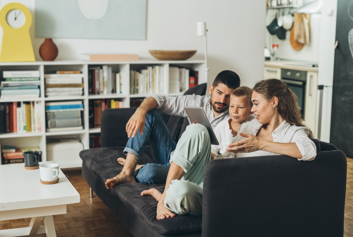 Family on couch looking at tablet together