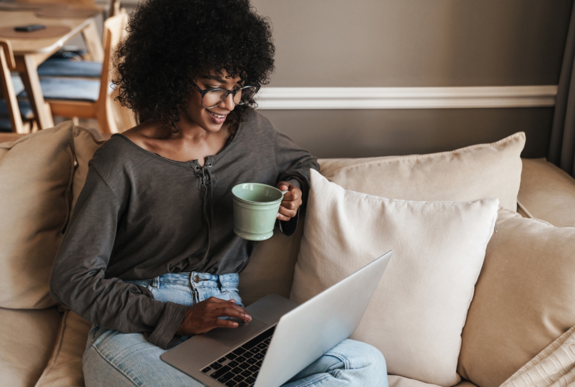 Women sitting on couch with a computer on her lap