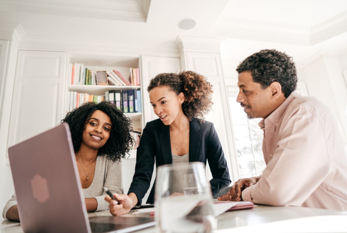 Three business people in an office planning something on a computer