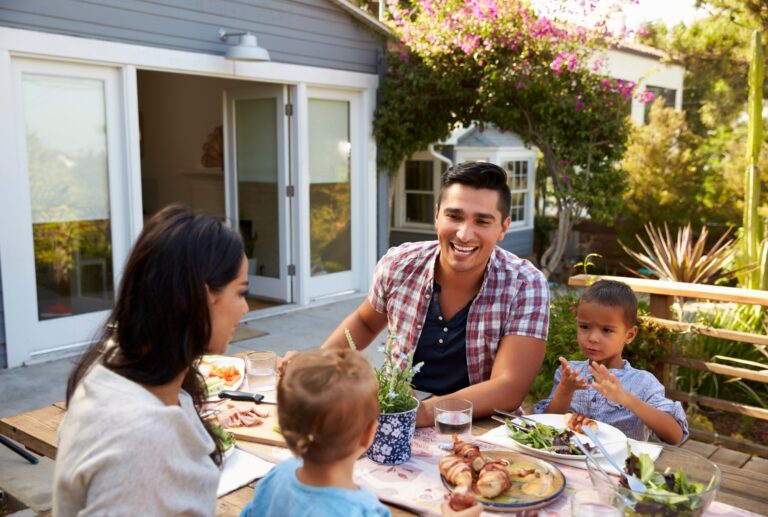 Family in backyard of house having a meal